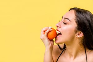 Woman biting orange